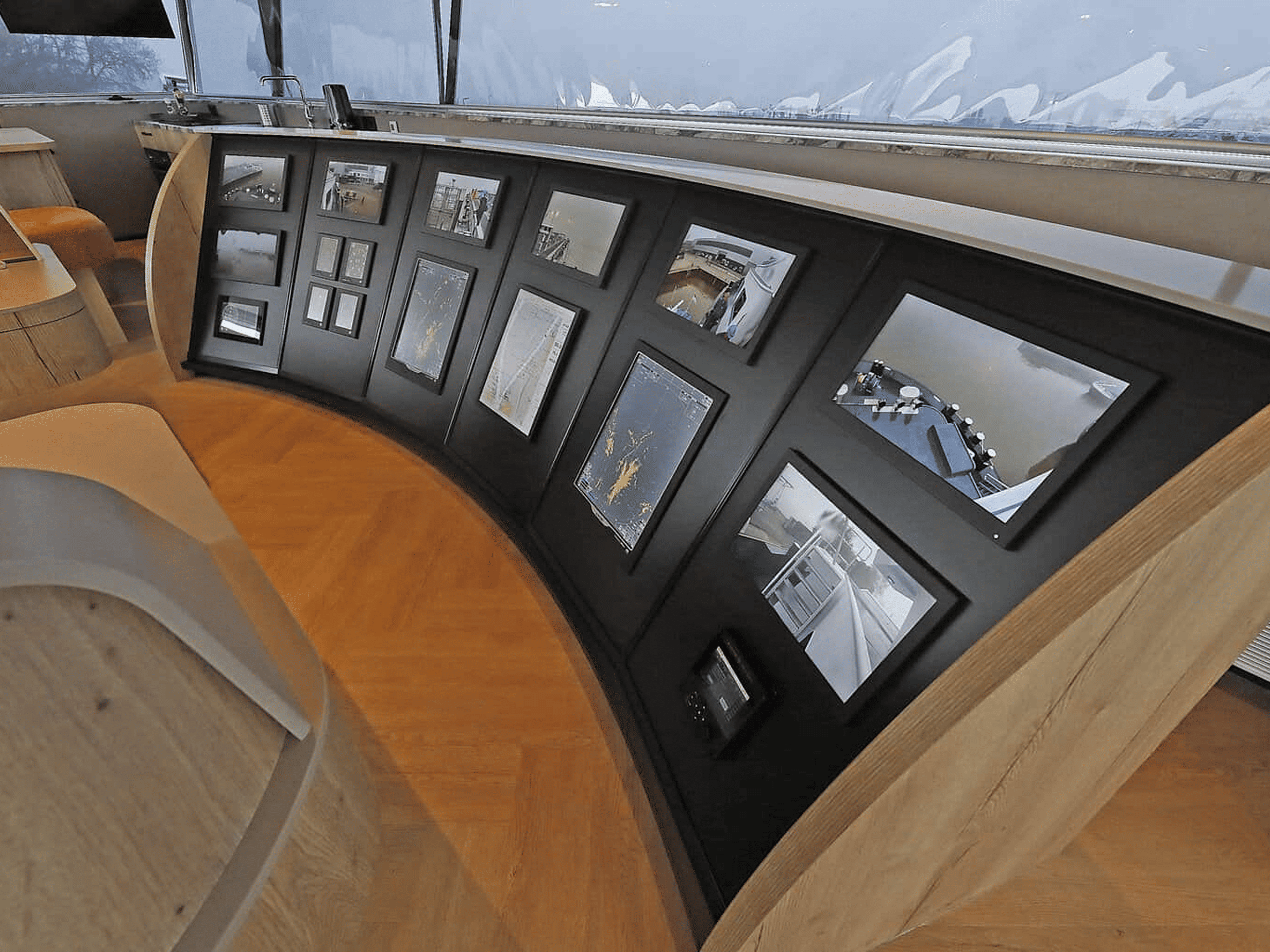 Multiple marine monitors showing navigation data in a wheelhouse.